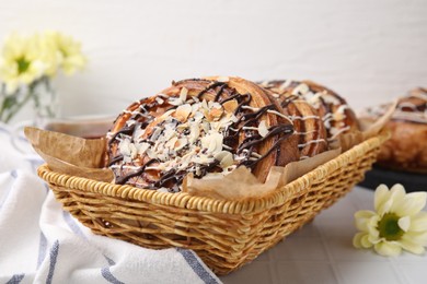 Delicious rolls with toppings and almond on white tiled table, closeup. Sweet buns