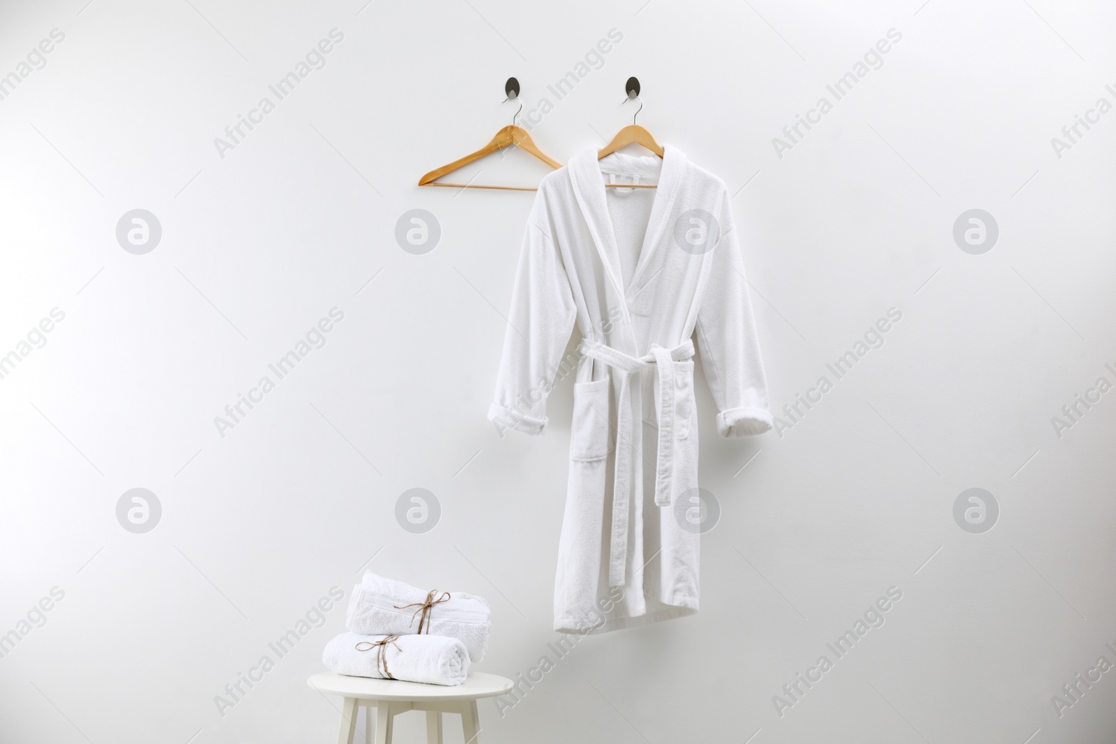 Photo of Soft comfortable bathrobe and fresh towels indoors