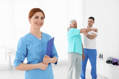 Photo of Portrait of professional physiotherapist with clipboard in rehabilitation center. Space for text