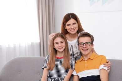 Happy mother with her teenager daughter and son at home