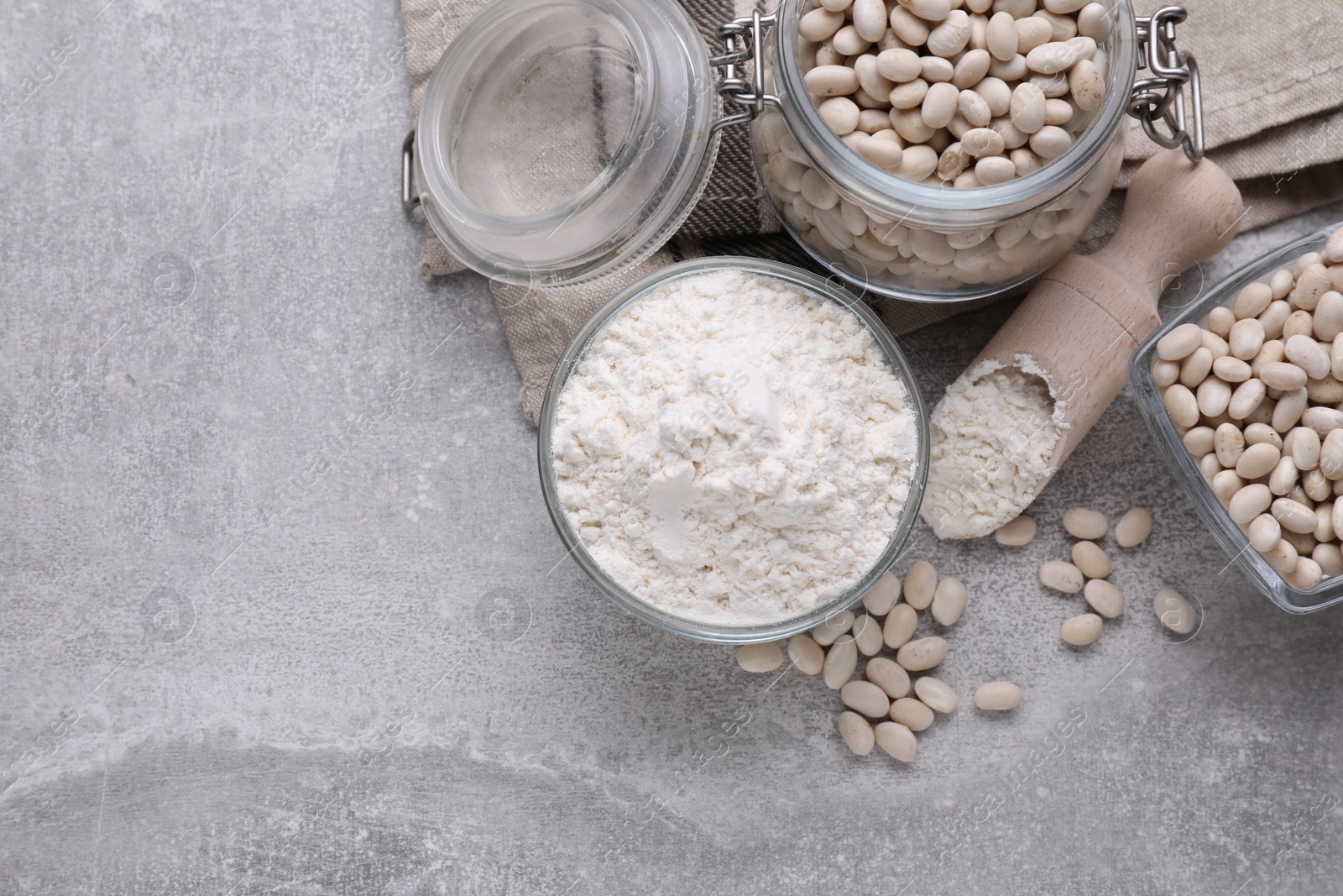 Photo of Bean flour and seeds on light grey table, flat lay. Space for text