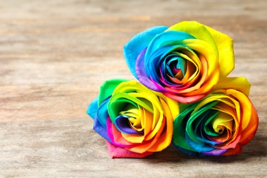 Photo of Amazing rainbow rose flowers on table