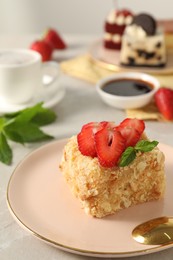 Photo of Piece of delicious Napoleon cake with fresh strawberries on light table, closeup. Space for text