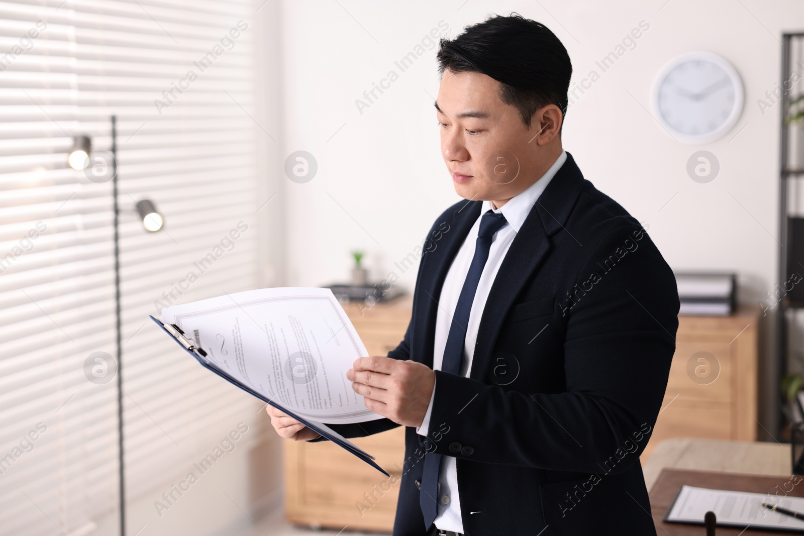 Photo of Portrait of confident notary with clipboard in office