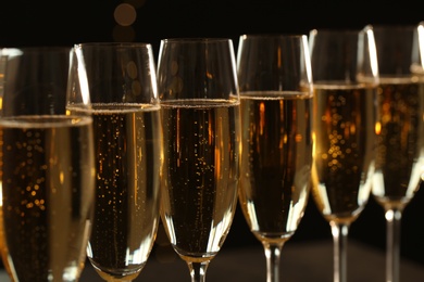 Photo of Glasses of champagne on dark background, closeup