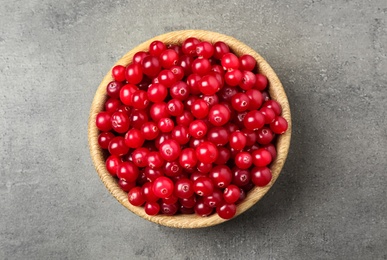 Photo of Tasty ripe cranberries on grey table, top view