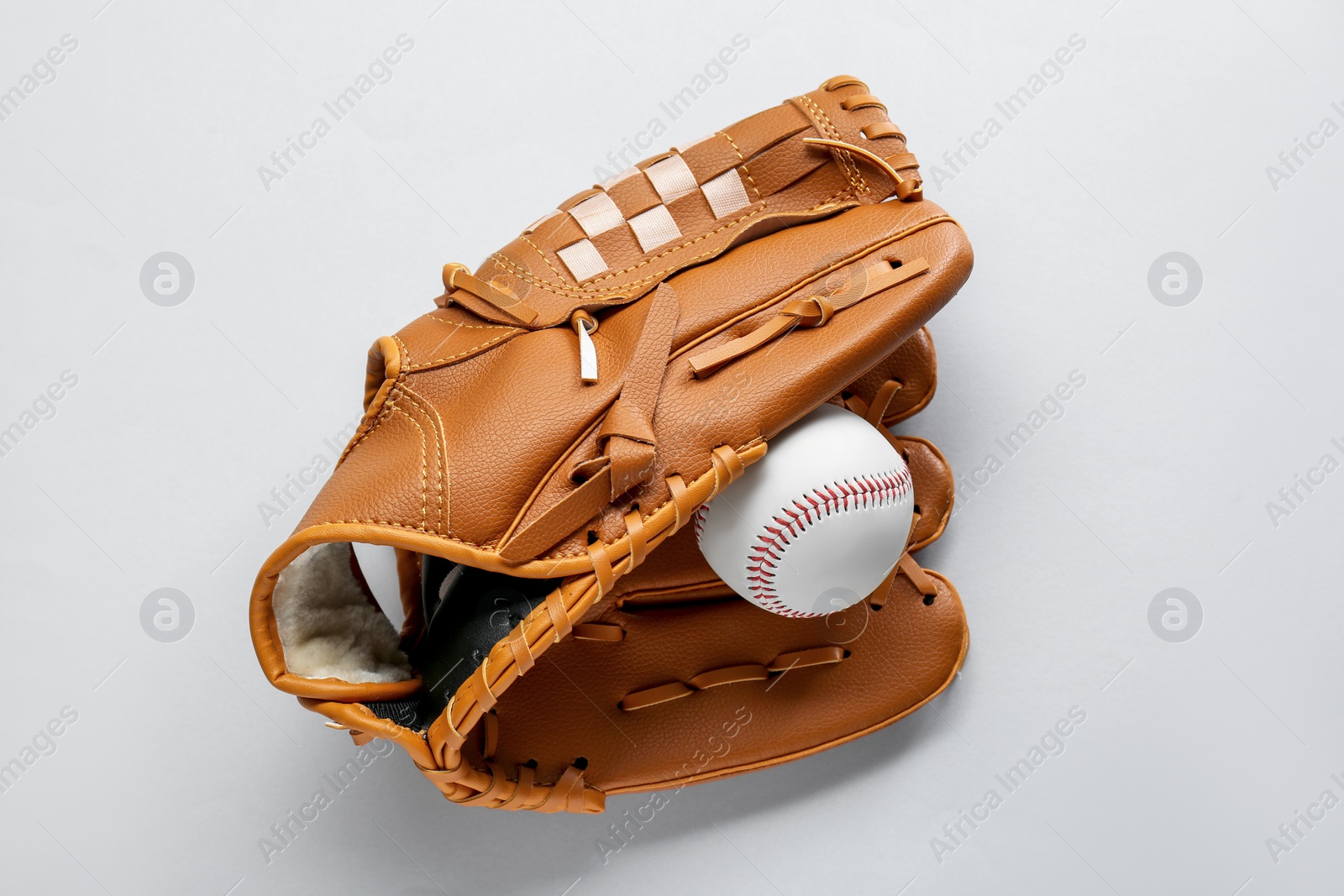 Photo of Catcher's mitt and baseball ball on white background, top view. Sports game