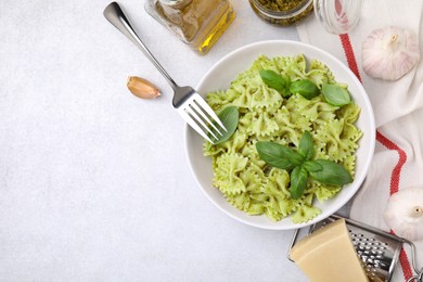 Delicious pasta with pesto sauce and basil on white table, flat lay. Space for text