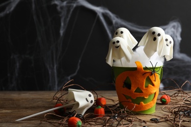 Photo of Ghost shaped cake pops on wooden table, space for text. Halloween treat