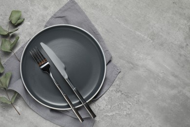 Stylish setting with elegant cutlery on grey table, top view. Space for text