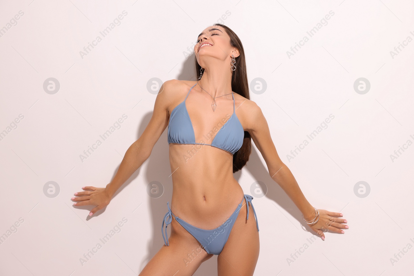 Photo of Young woman in stylish bikini on white background