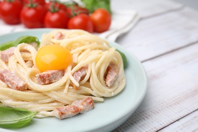 Photo of Delicious pasta Carbonara with egg yolk on white wooden table, closeup