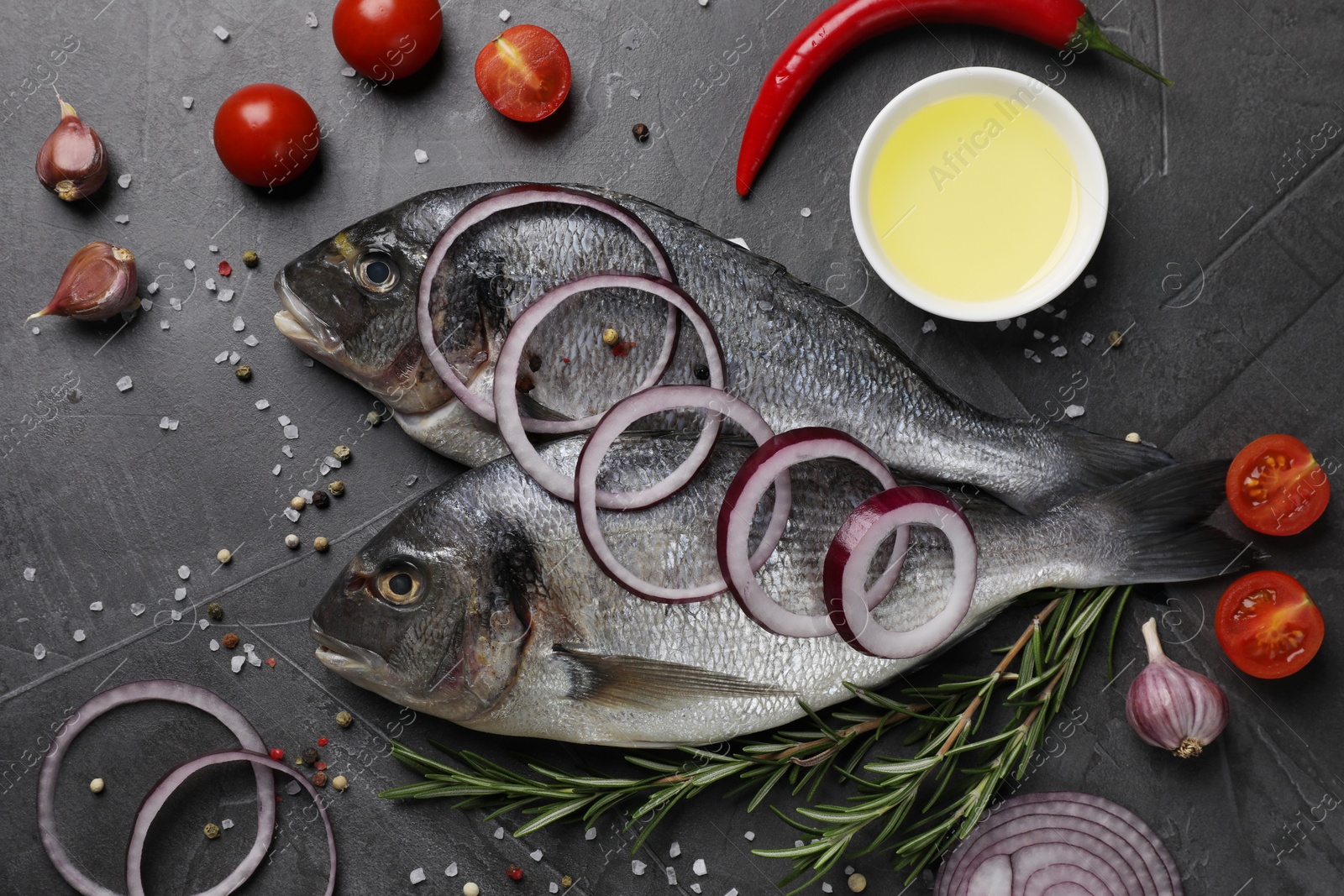 Photo of Fresh dorado fish and ingredients on grey table, flat lay