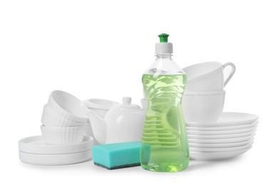 Photo of Clean tableware, bottle of detergent and sponge on white background. Washing dishes