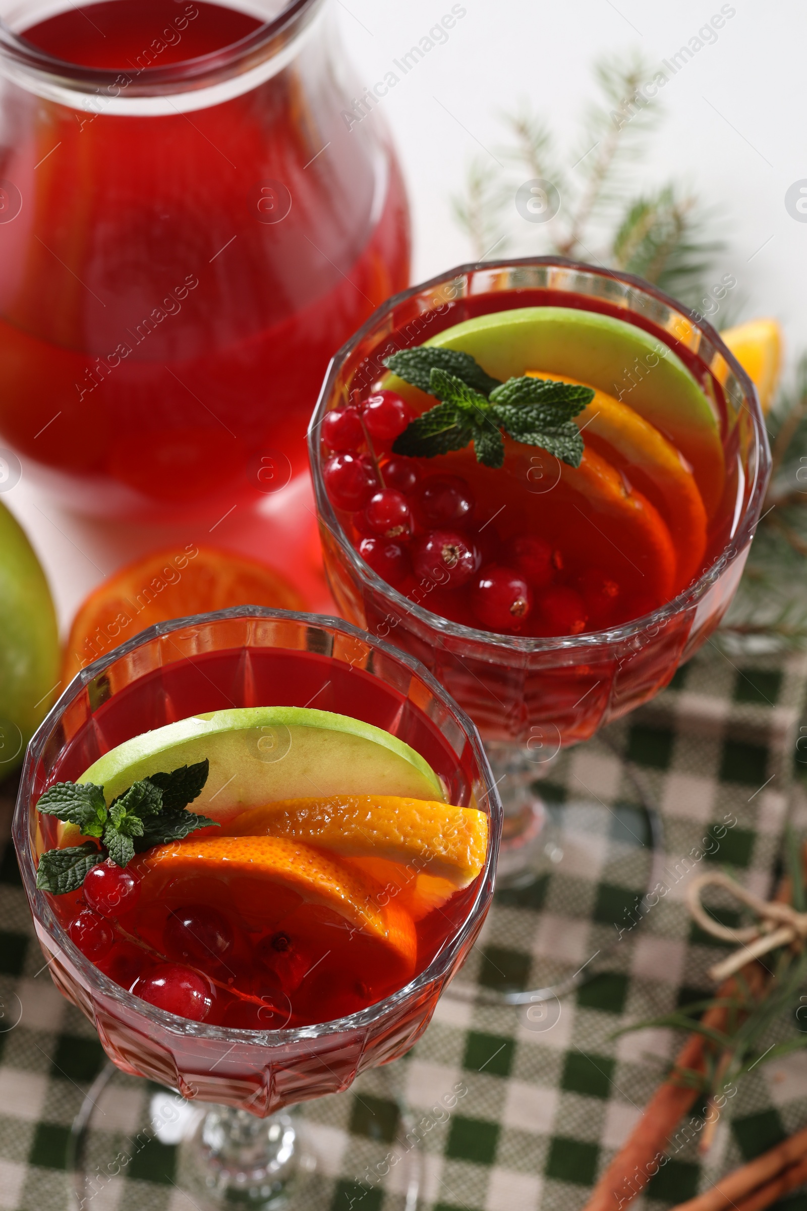 Photo of Christmas Sangria cocktail in glasses and ingredients on white table, above view