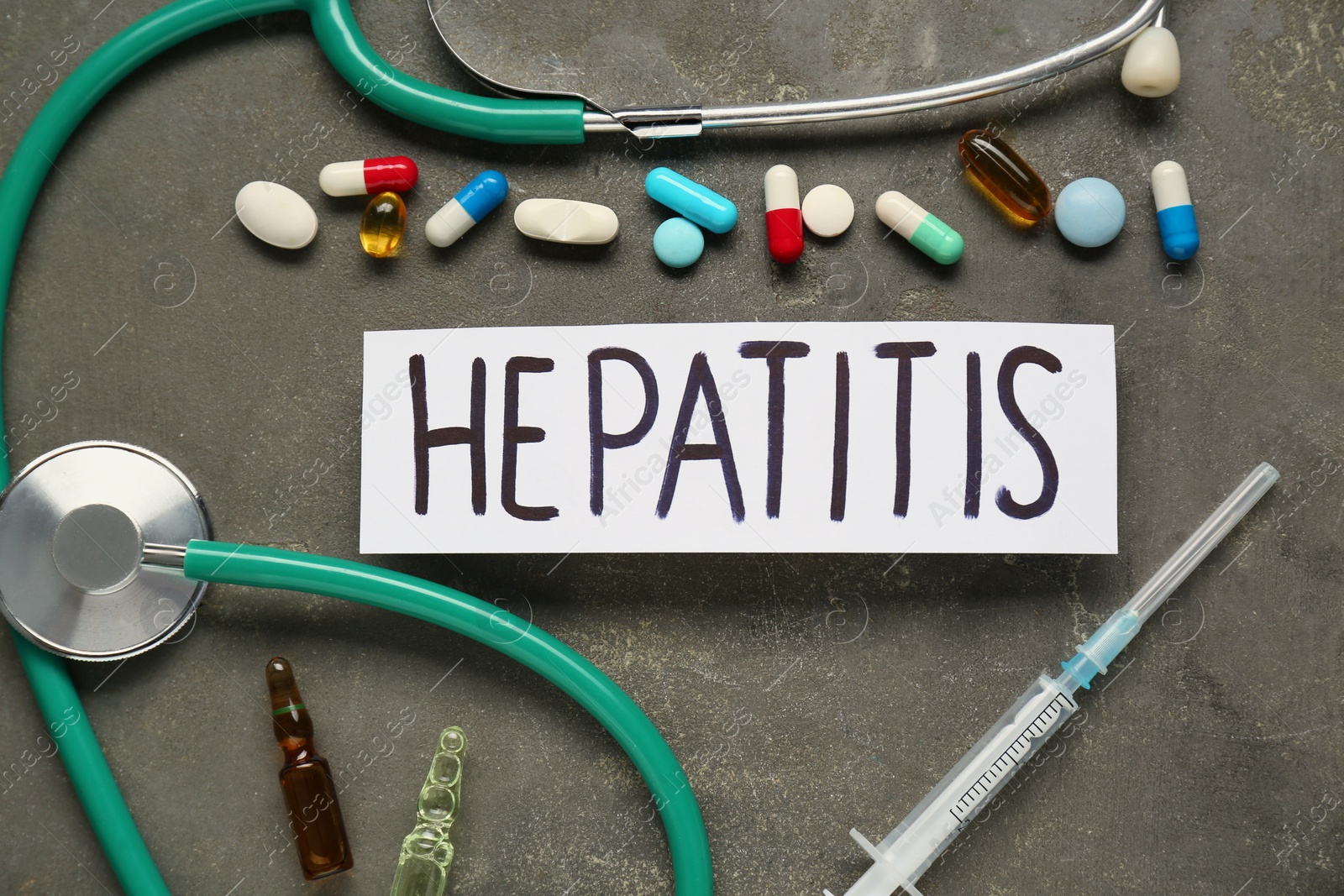 Photo of Word Hepatitis and medical supplies on grey table, flat lay