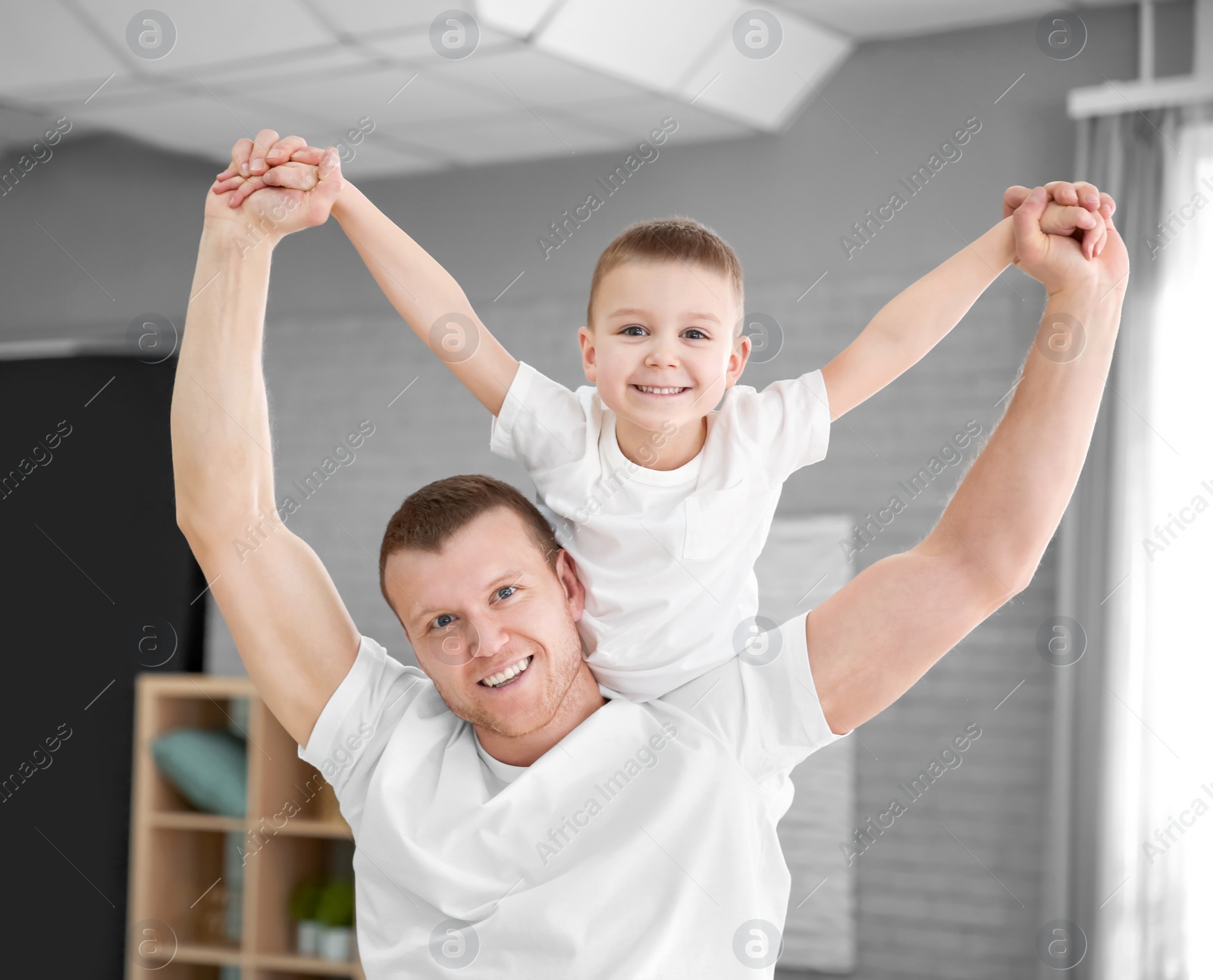 Photo of Happy dad playing with his son at home. Father's day celebration