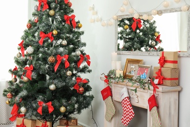 Decorated fireplace and Christmas tree in stylish living room interior