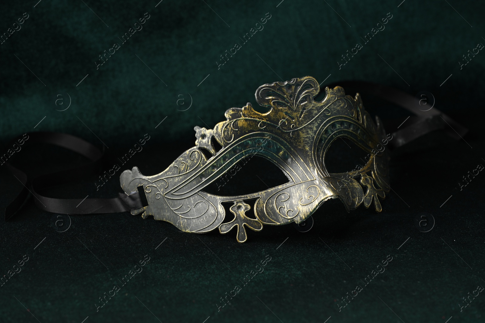 Photo of Theater arts. Venetian carnival mask on green fabric