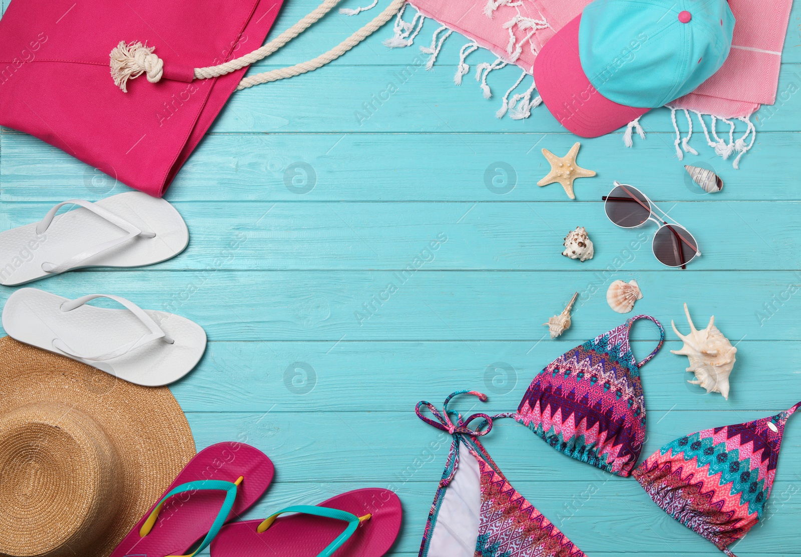 Photo of Flat lay composition with swimsuit and beach accessories on wooden background. Space for text