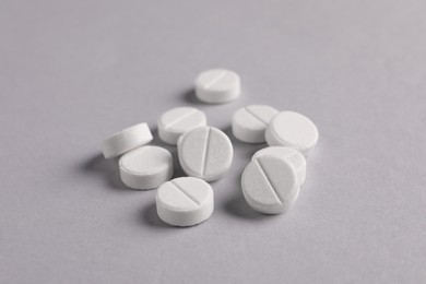 Photo of Pile of round pills on light grey background