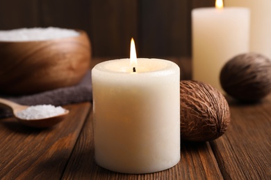 Burning scented candle and decor on wooden table