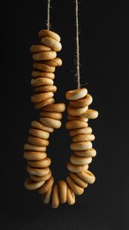 Bunch of delicious ring shaped Sushki (dry bagels) hanging on black background