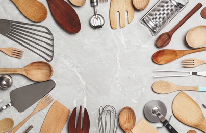 Frame of cooking utensils on grey marble table, flat lay. Space for text