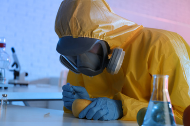 Photo of Scientist in chemical protective suit injecting apple at laboratory