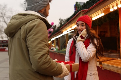 Photo of Lovely couple with Christmas present at winter fair