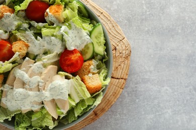 Photo of Bowl of delicious salad with Chinese cabbage, cucumber, meat and tomatoes on grey table, top view. Space for text