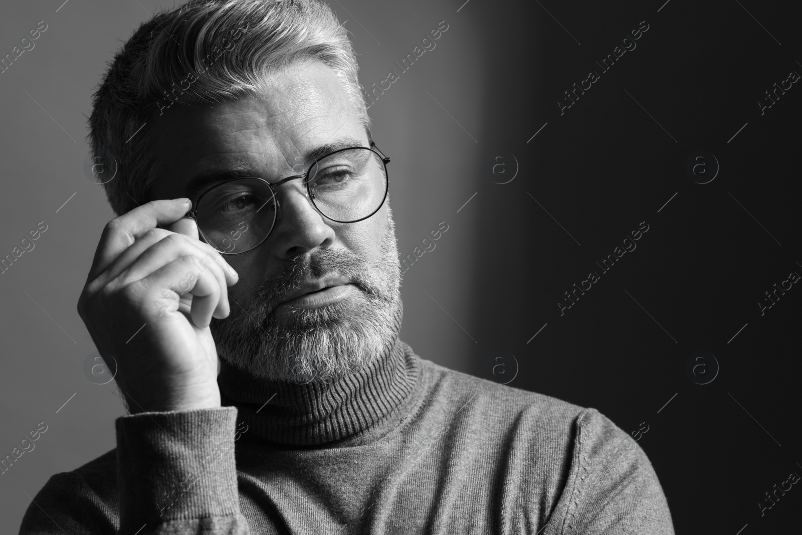 Photo of Portrait of handsome man on dark background, space for text. Black and white effect