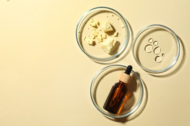 Many Petri dishes and cosmetic products on beige background, flat lay. Space for text