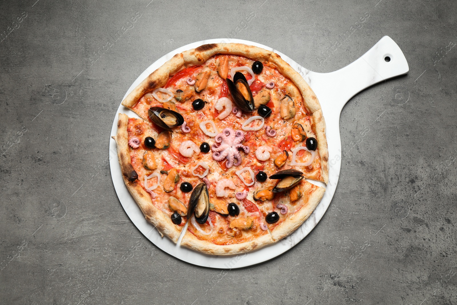 Photo of Delicious seafood pizza on grey table, top view