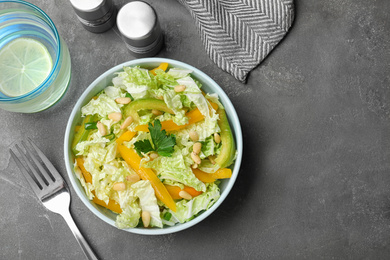 Fresh cabbage salad with bell pepper served on grey table, flat lay