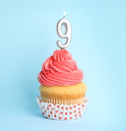 Photo of Birthday cupcake with number nine candle on blue background