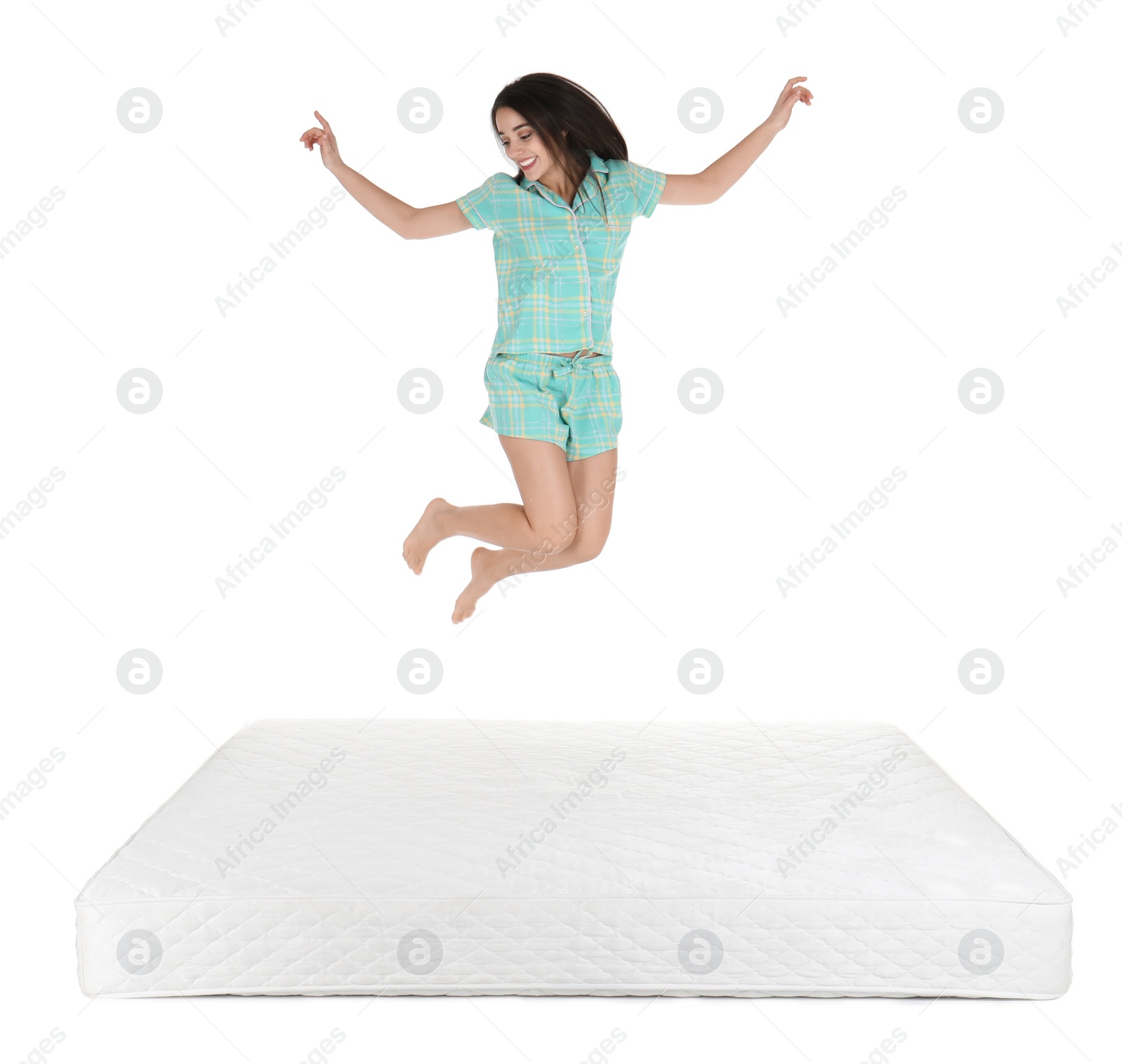 Photo of Young woman jumping on mattress against white background