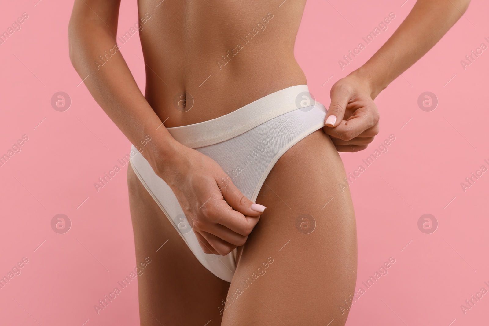 Photo of Young woman in stylish white bikini on pink background, closeup