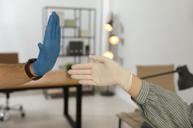 Man refusing handshake from coworker in office, closeup