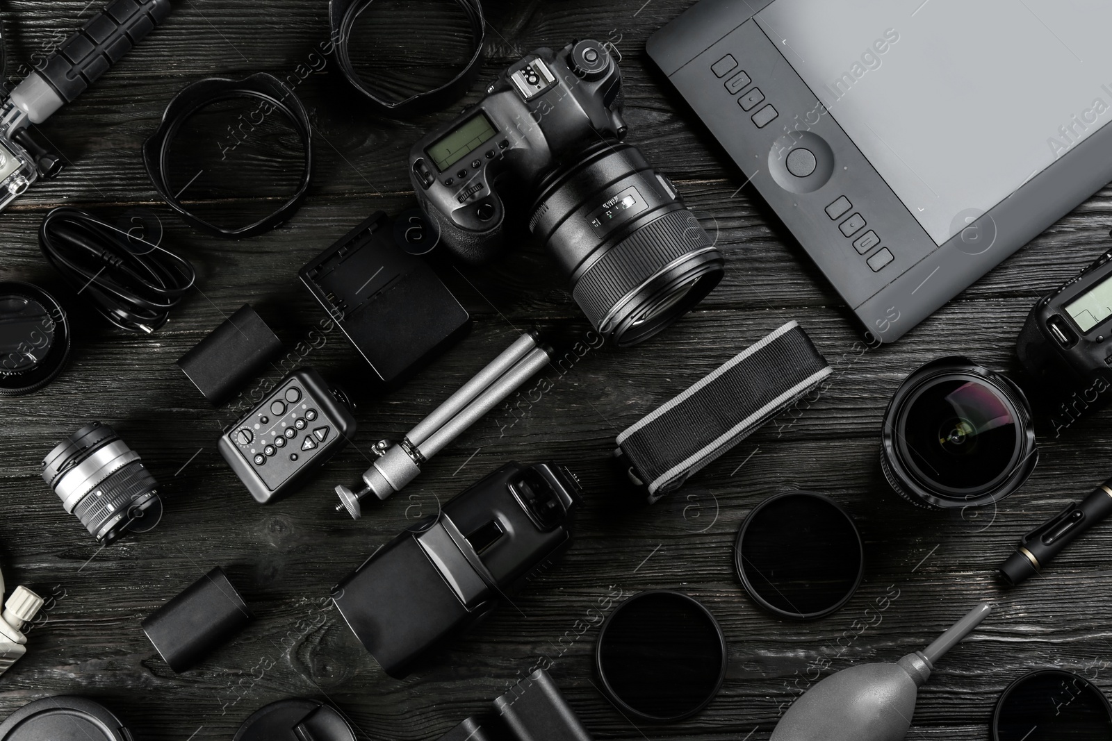 Photo of Flat lay composition with equipment for professional photographer on black wooden table