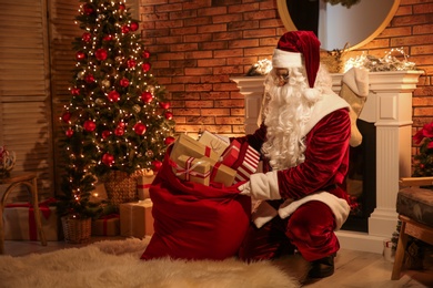 Santa Claus with sack of gifts in festively decorated room