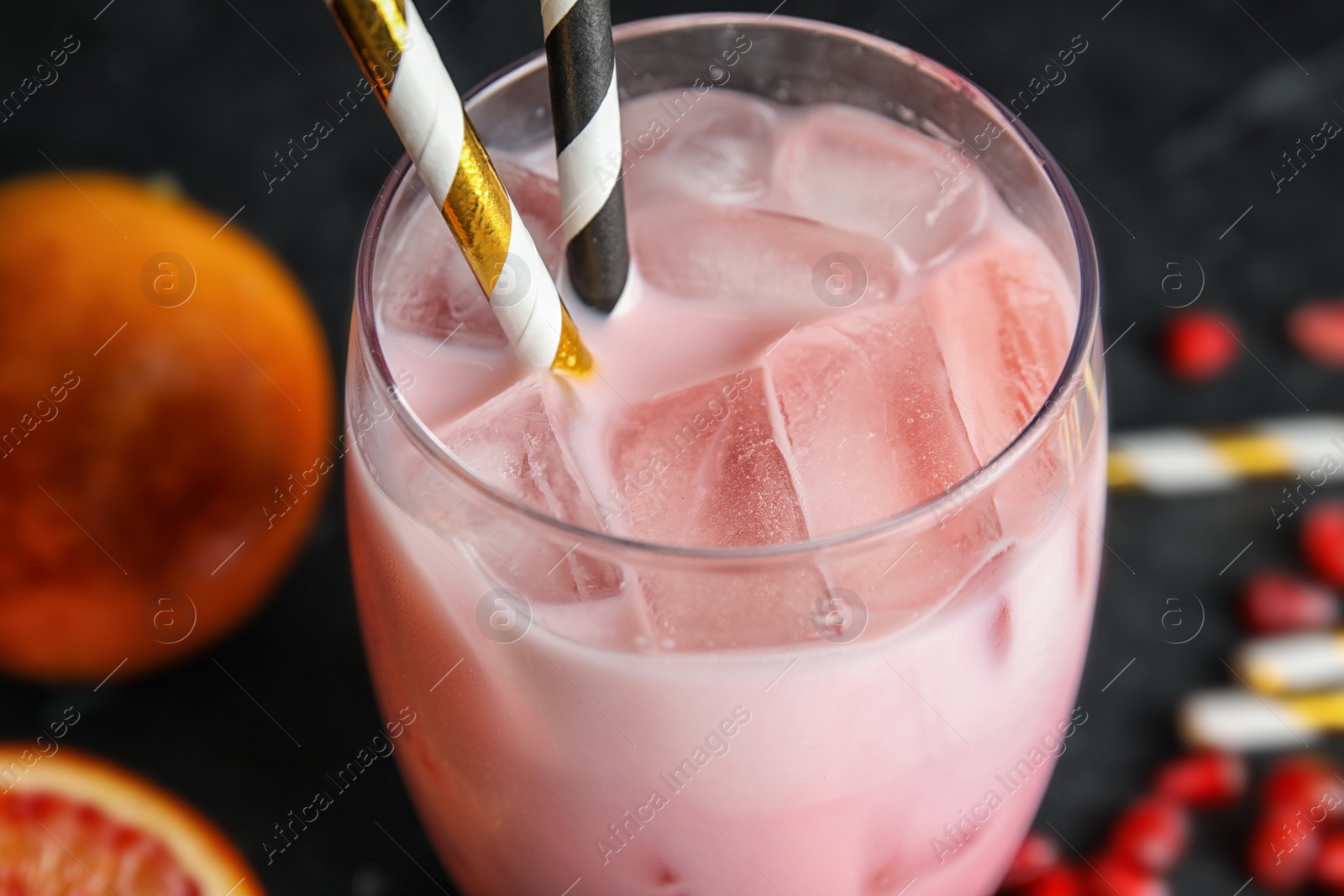 Photo of Glass of tropical cocktail with ice cubes on table, closeup