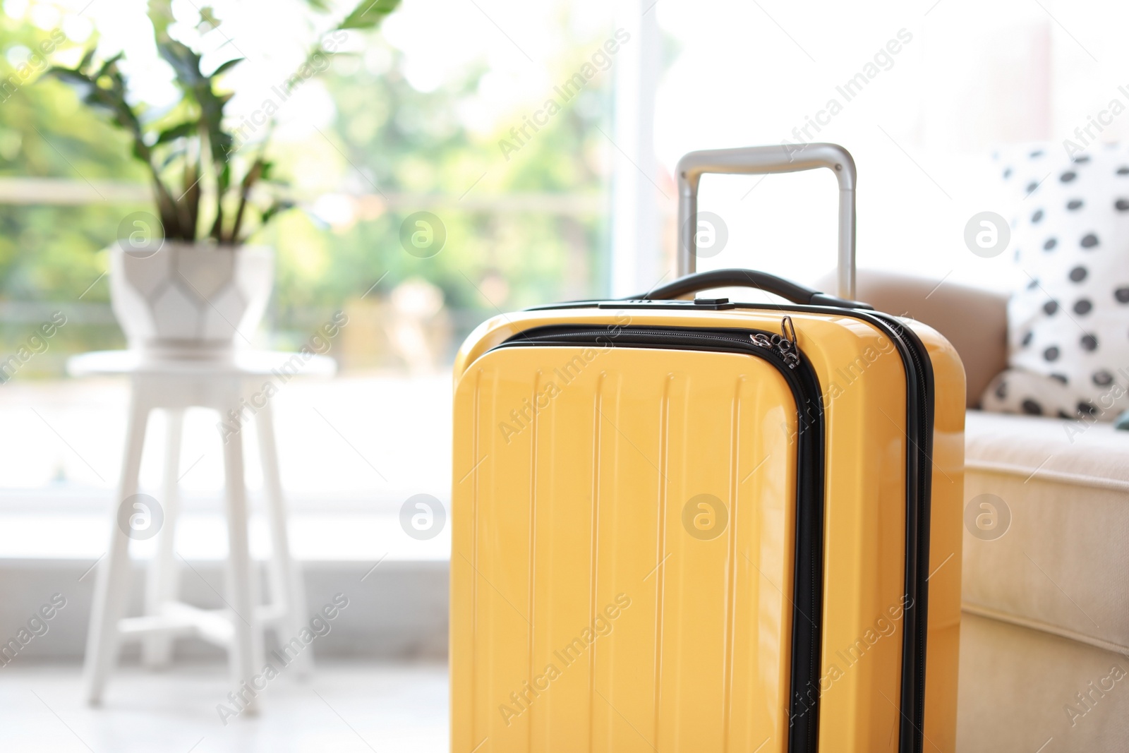 Photo of Bright yellow suitcase packed for journey at home