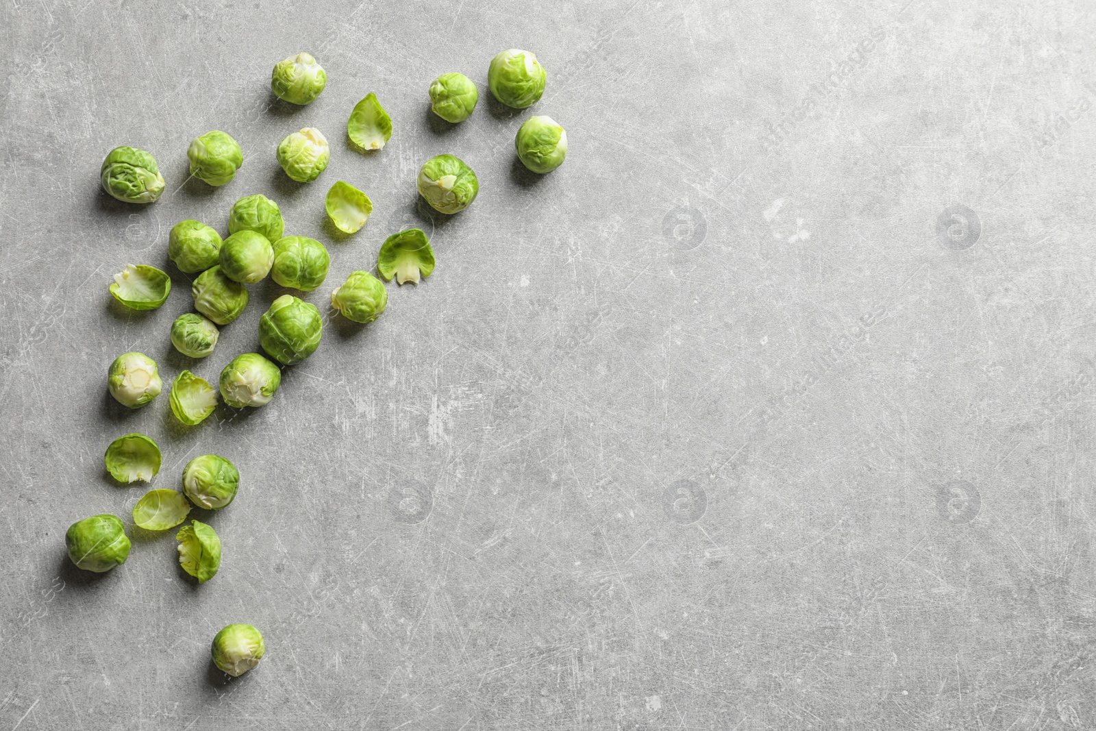 Photo of Fresh Brussels sprouts on grey background, top view with space for text