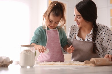 Photo of Mother and daughter making pastry in kitchen at home