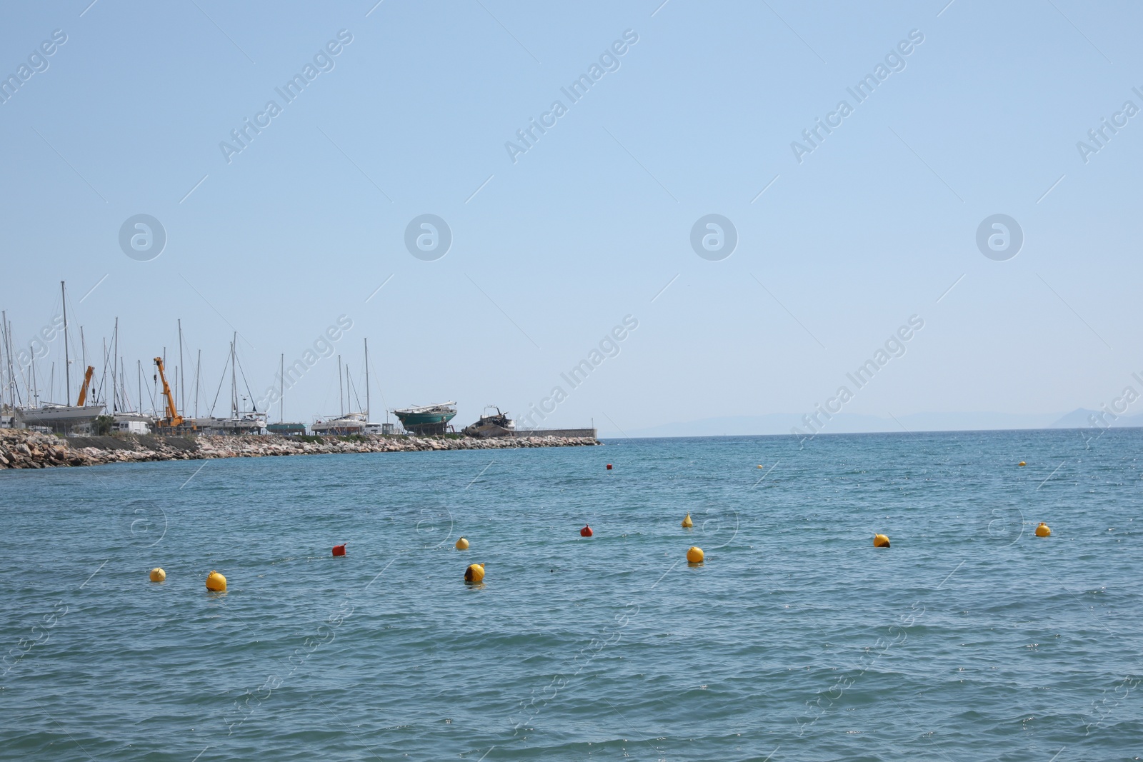 Photo of Picturesque view of pier with boats and calm sea on sunny day