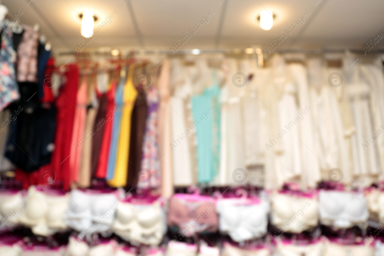 Photo of Blurred view of female nighties on hangers in underwear shop