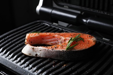 Photo of Cooking salmon. Grill with fresh fish steak, spices and rosemary