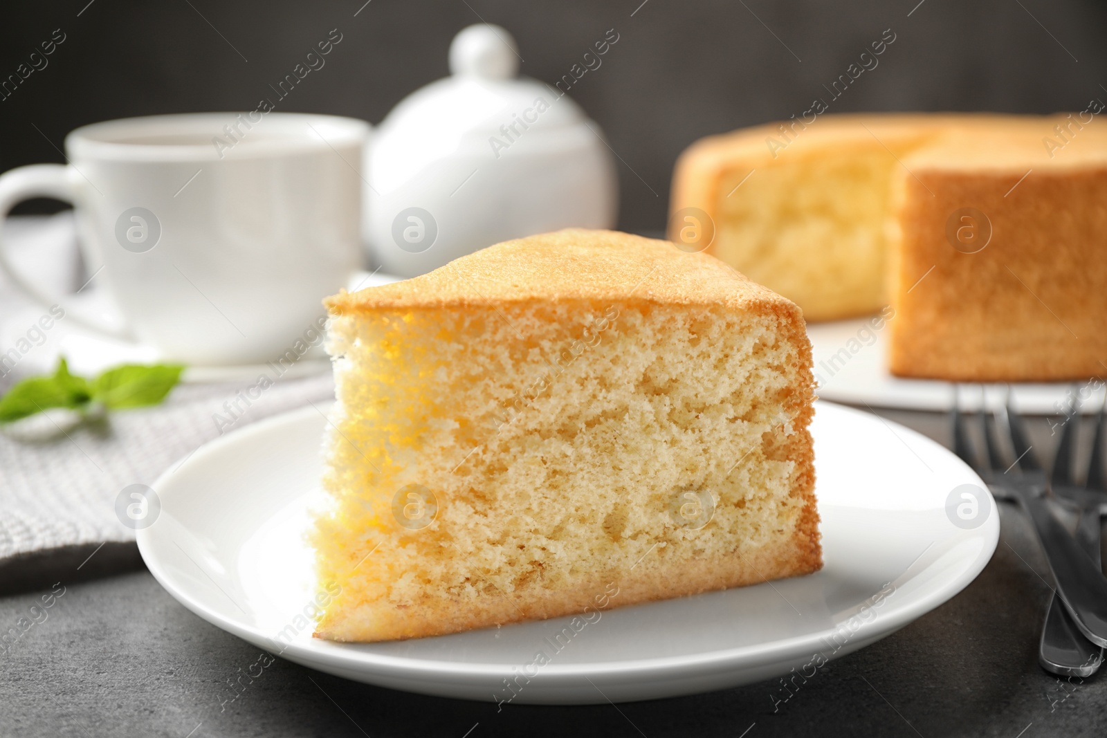 Photo of Piece of delicious fresh homemade cake on grey marble table