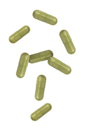 Vitamin. Many capsules falling on white background